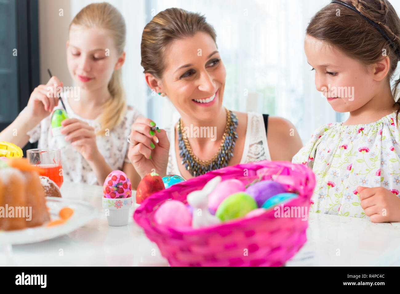 Family having fun coloring Easter eggs Stock Photo - Alamy