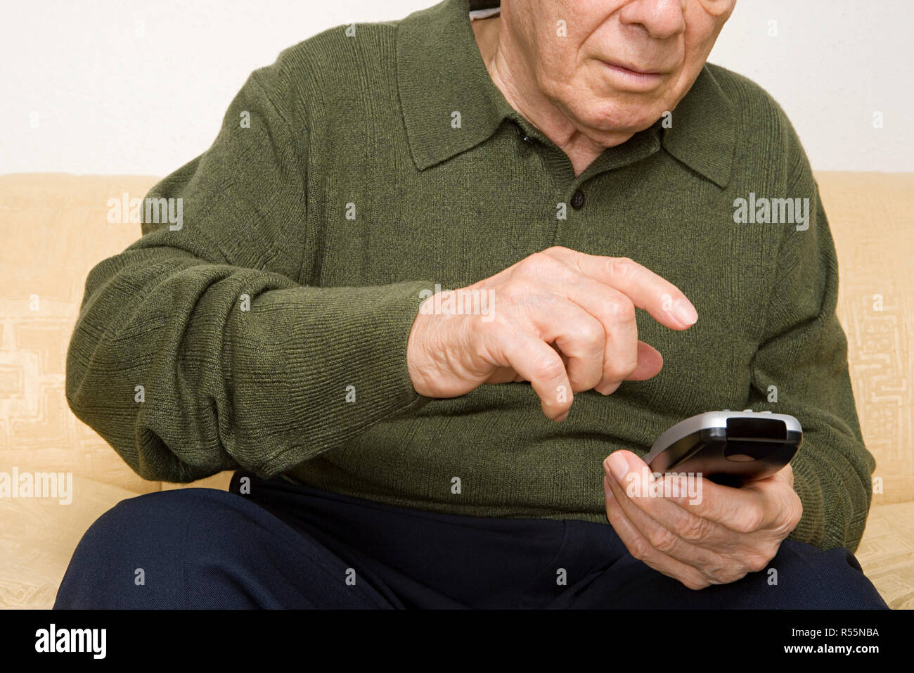 Elderly man using remote control Stock Photo - Alamy
