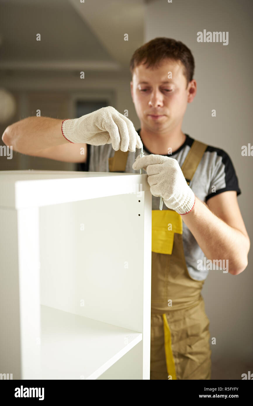 Man assembling white wardrobe in room background Stock Photo Alamy