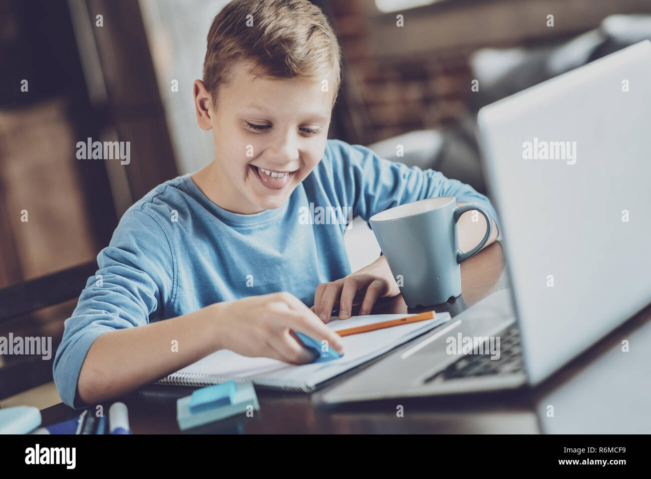 Positive delighted kid using highlighter in task Stock Photo Alamy