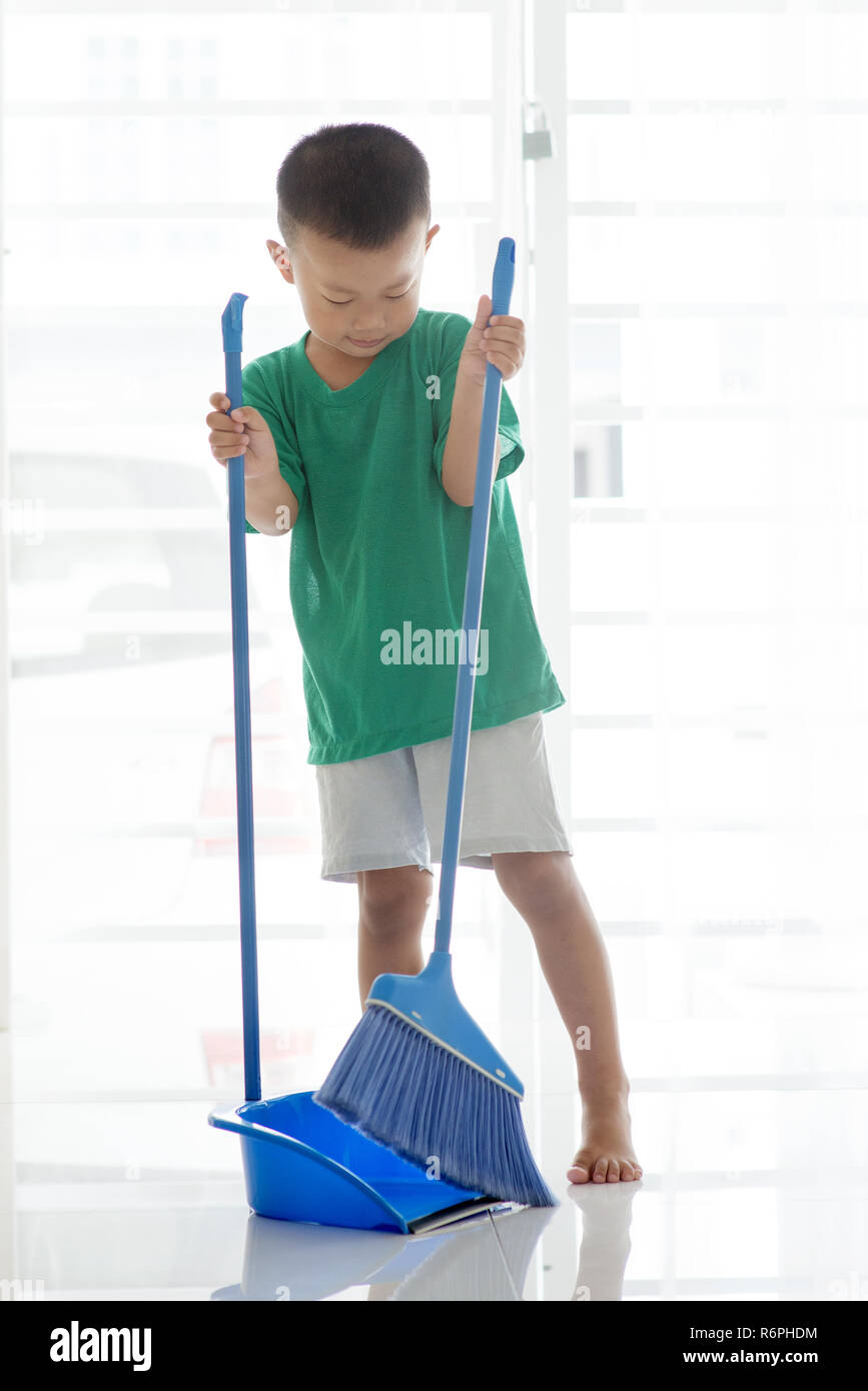 Young boy sweeping floor Stock Photo Alamy