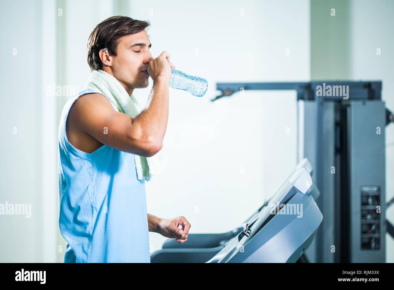 Man drinking water while exercising in gym Stock Photo Alamy