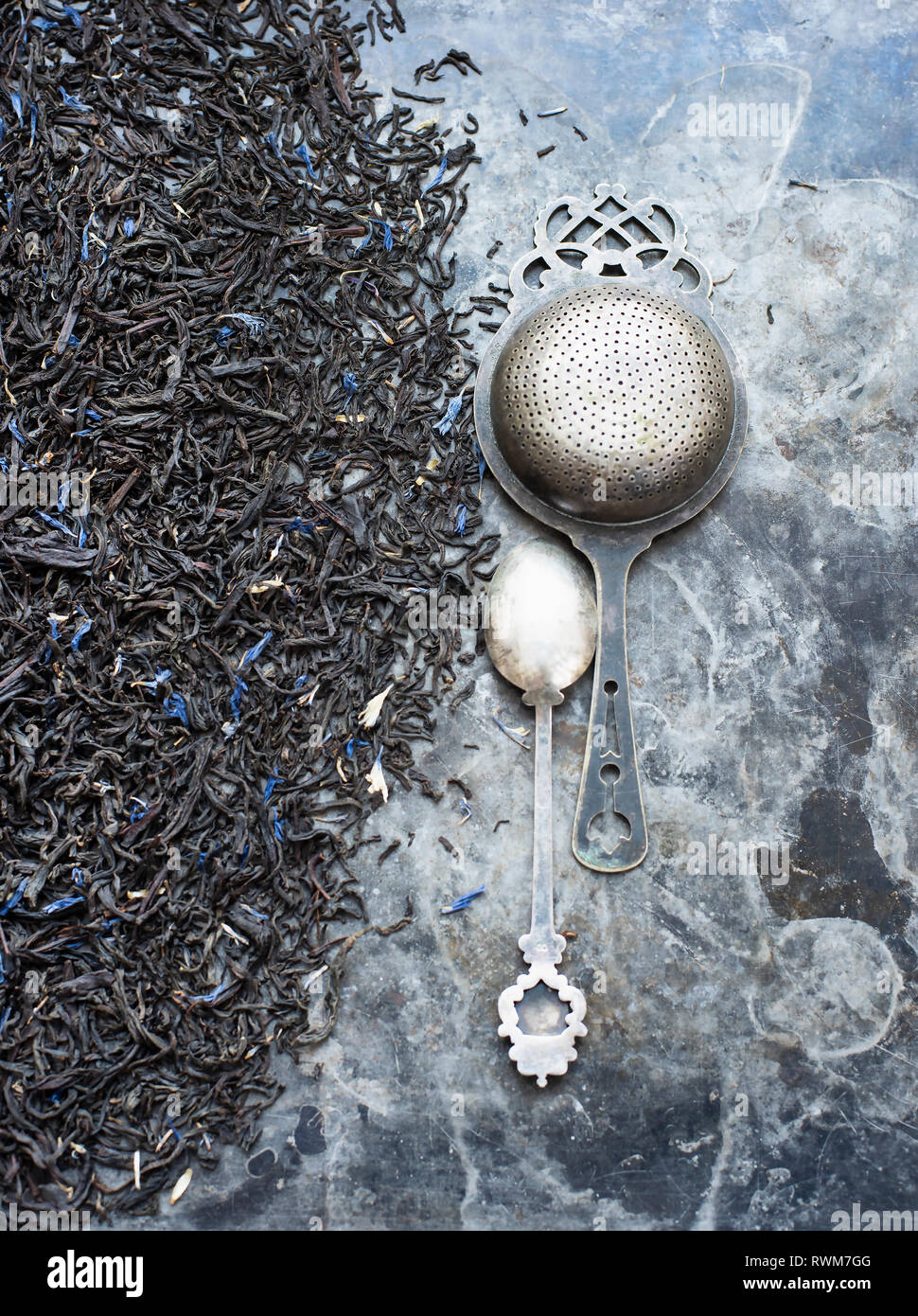 Tea leaves, tea strainer and silver spoon Stock Photo Alamy