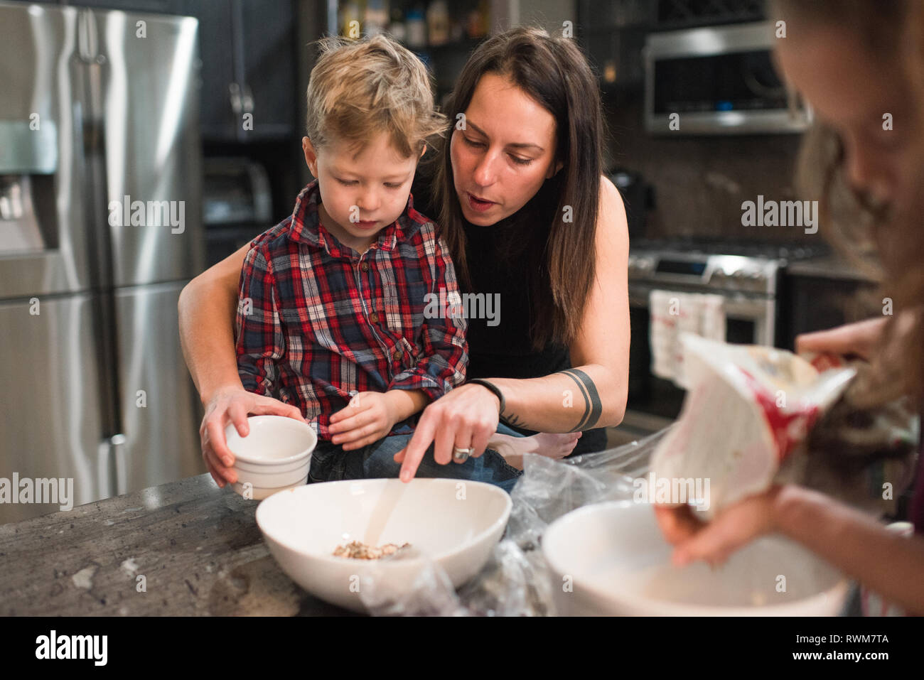 Children helping mother in kitchen Stock Photo Alamy