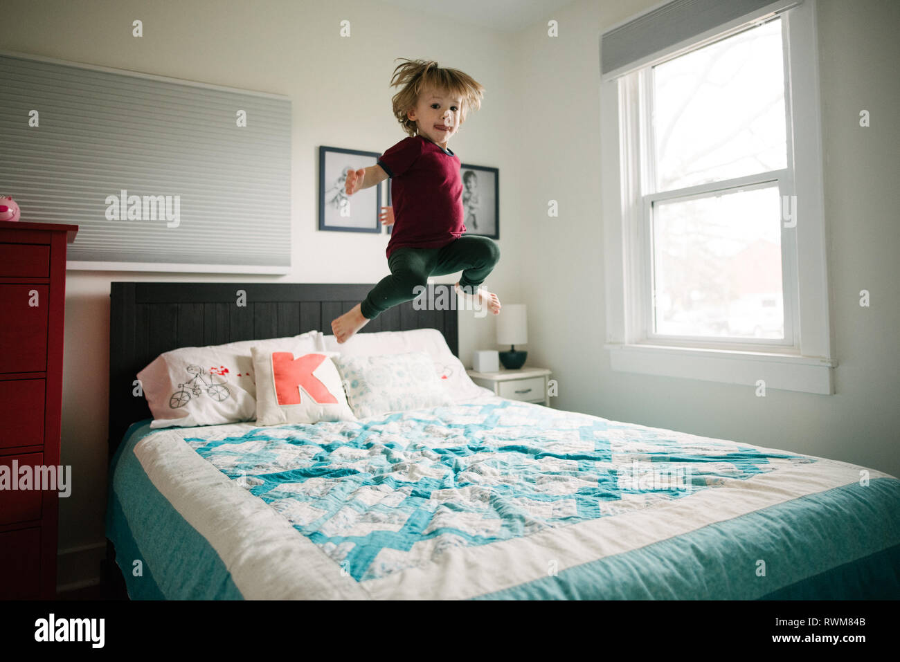 Boy jumping on bed Stock Photo Alamy