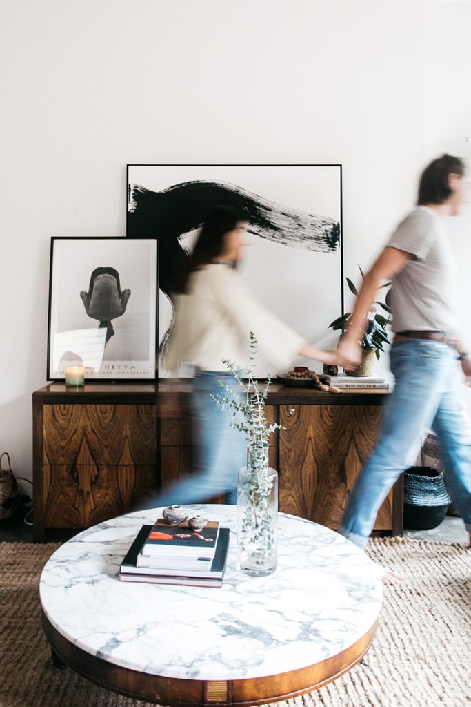 Couple holding hands in living room.