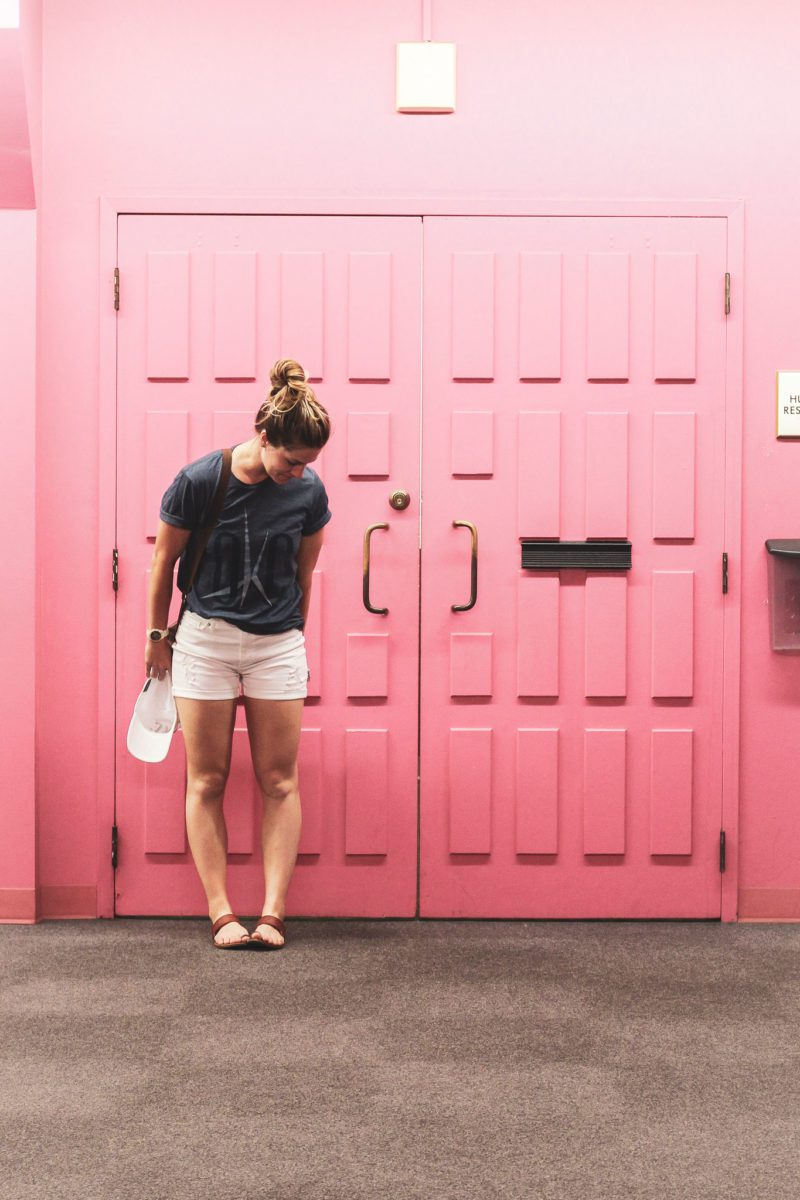 girl in front of okc pink wall