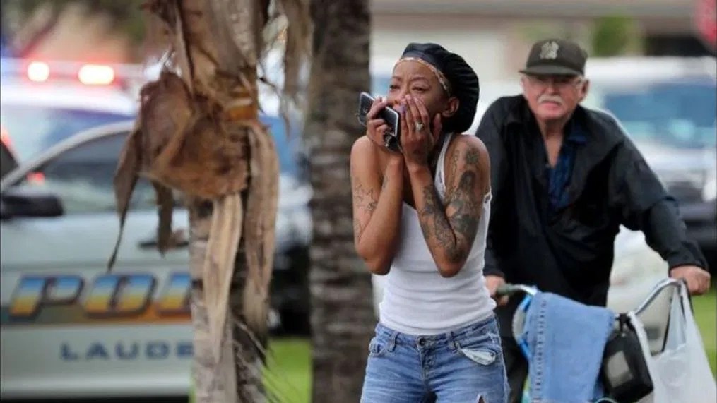 A woman reacts to the news of two young adults that were slashed with a