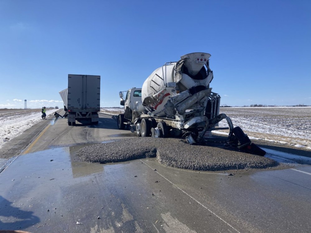 Puddle of concrete left on highway after semi collides with cement truck