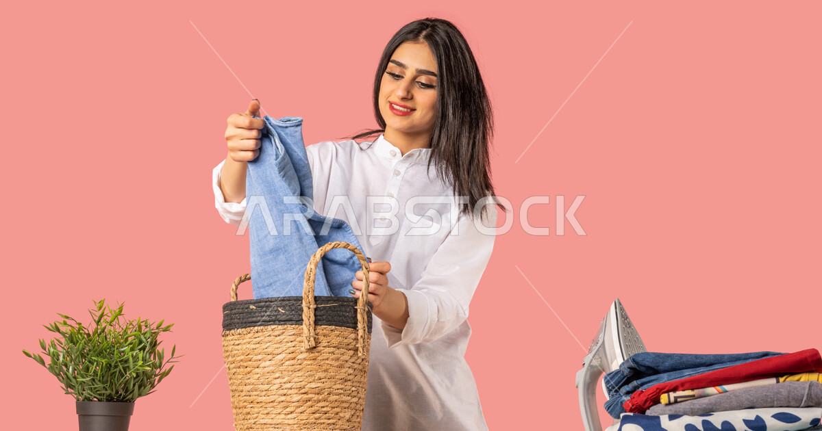 Portrait of a Saudi Arabian Gulf woman, holding clothes in her hand