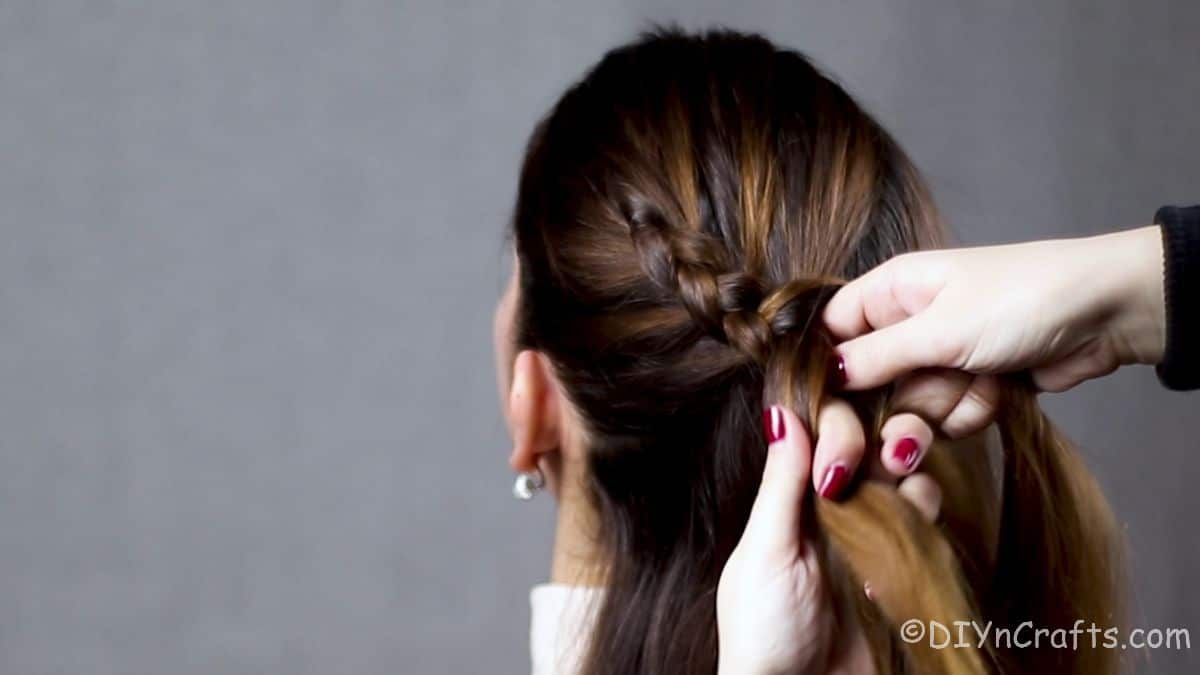 Dutch braid being moved around back of head