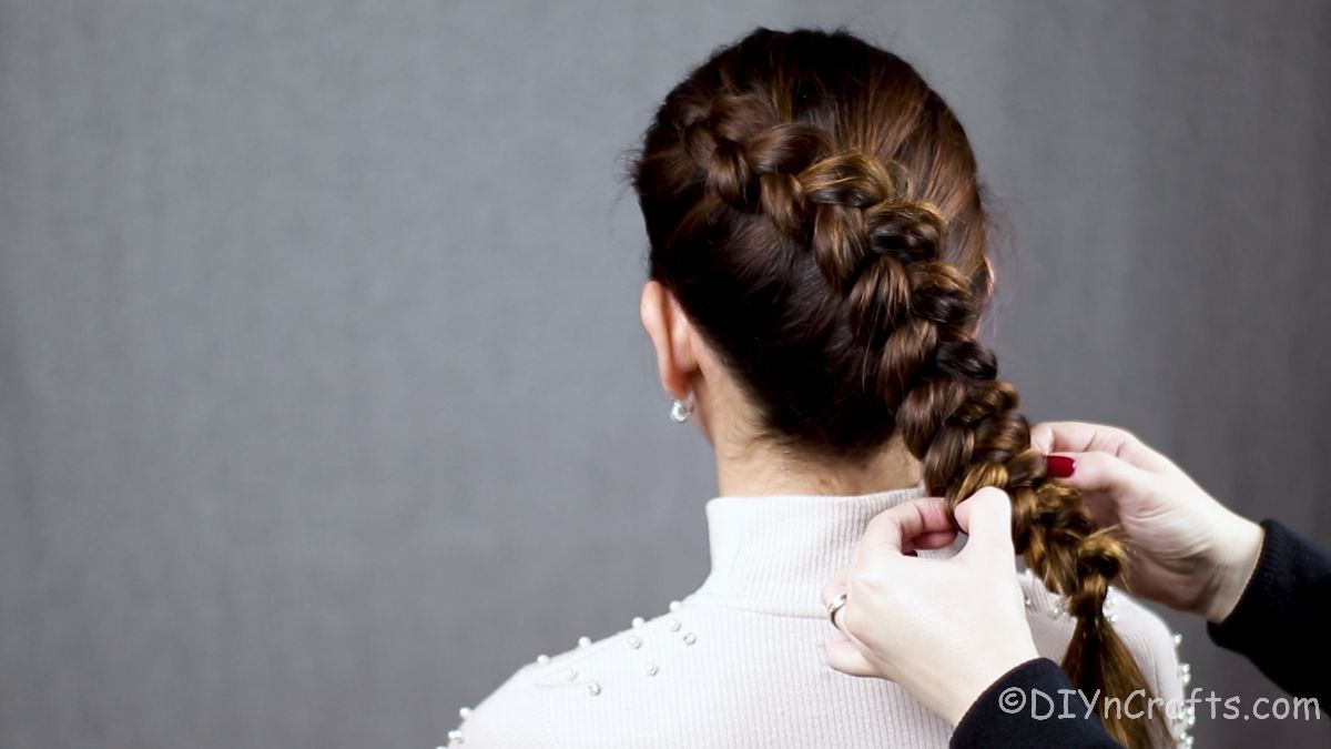 hands fluffing the back of a Dutch braid