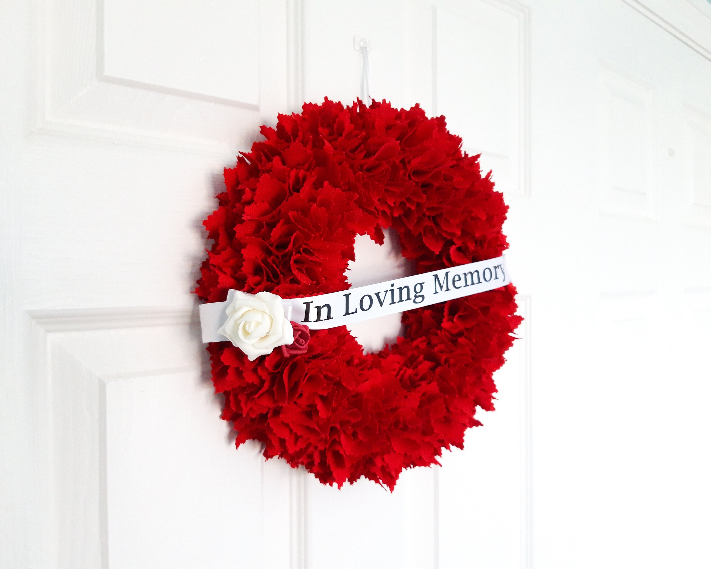 Honoring The Memory Of The Deceased With Red Flowers At Funerals And