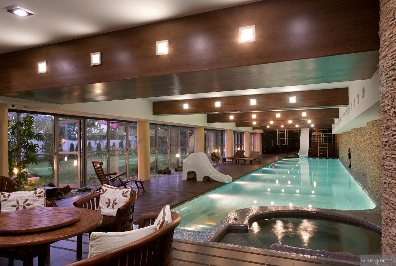 impressive exposed beam indoor swimming pool with garden views at dusk impressive exposed beam indoor swimming pool with garden views at dusk