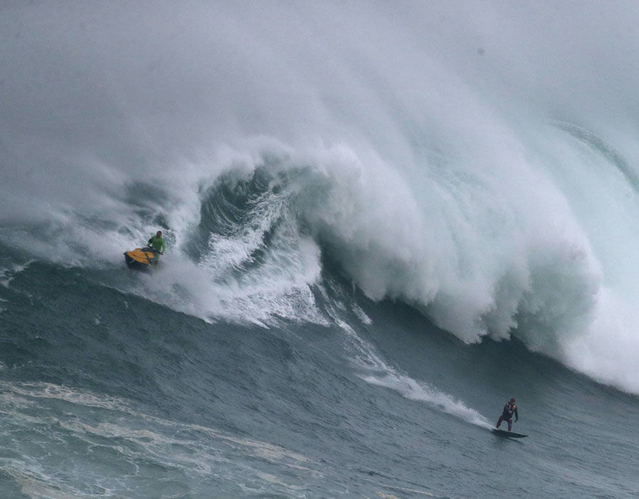 A surfer rides a big wave during a towin surfing session at the North