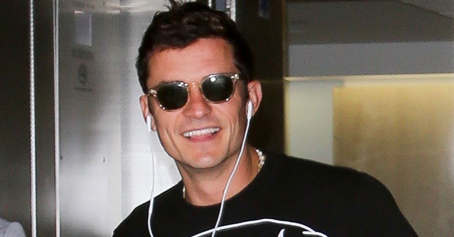 Orlando Bloom Lands Back in LA with Pup in Hand (& On Shirt) Orlando