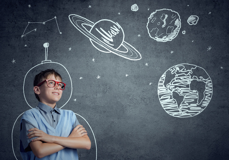 A boy daydreams about space travel.