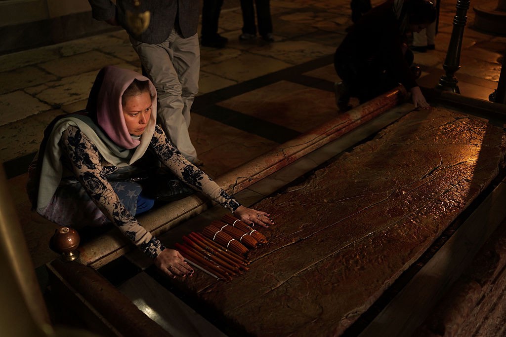 A pilgrim runs her hand across the Stone of Anointing in the Church of the Holy Sepulchre in 2014. This stone is traditionally held to be the spot where Jesus Christ&rsquo;s body was prepared for burial after crucifixion. Pilgrims have been coming to the church