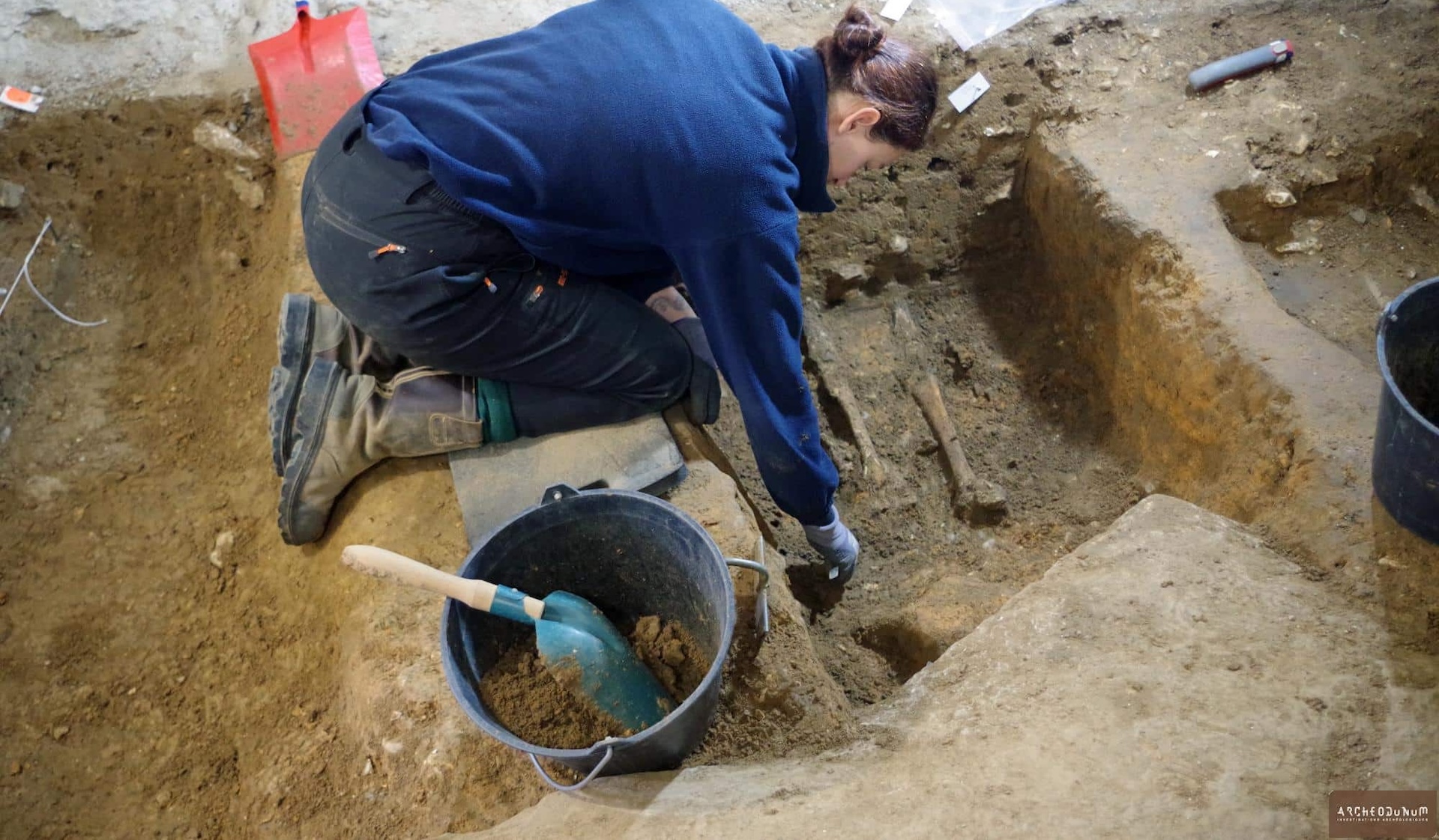 A woman excavates a grave