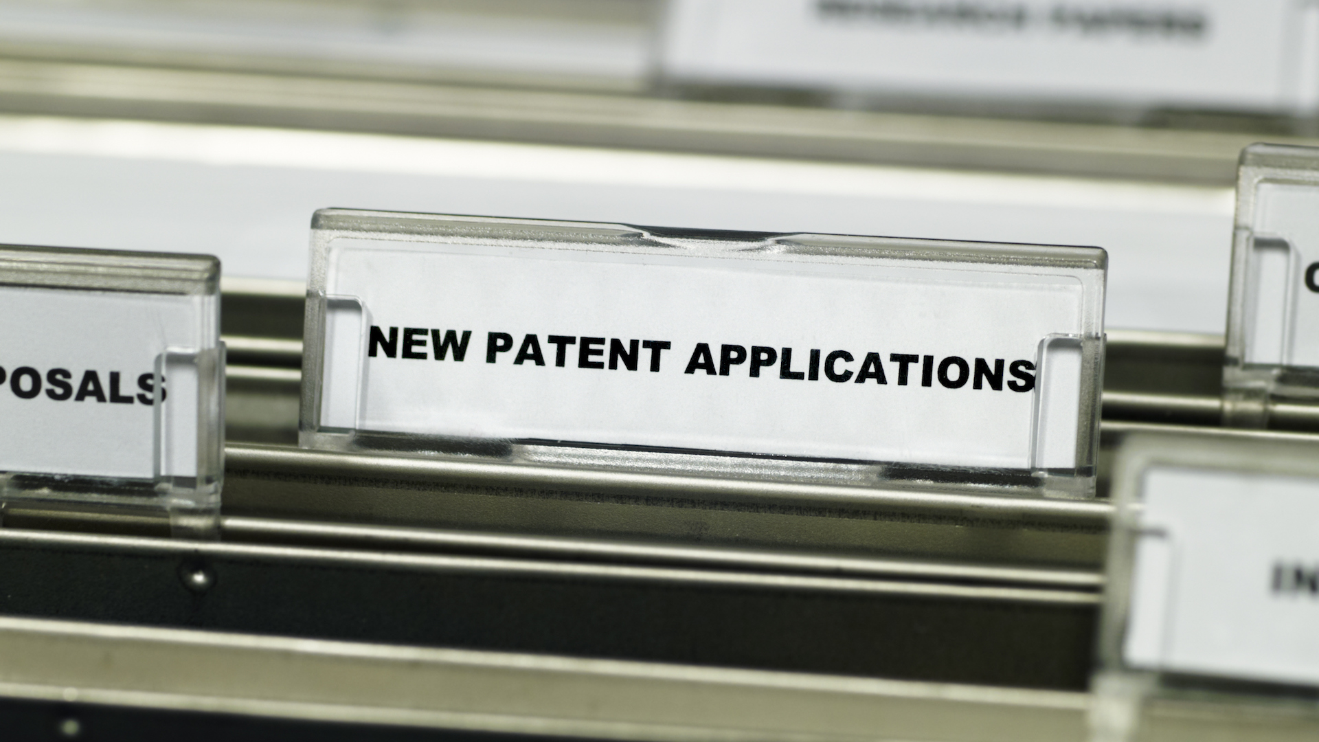 A row of folders from a patent office, with a label tab that reads &ldquo;new patent applications&rdquo;