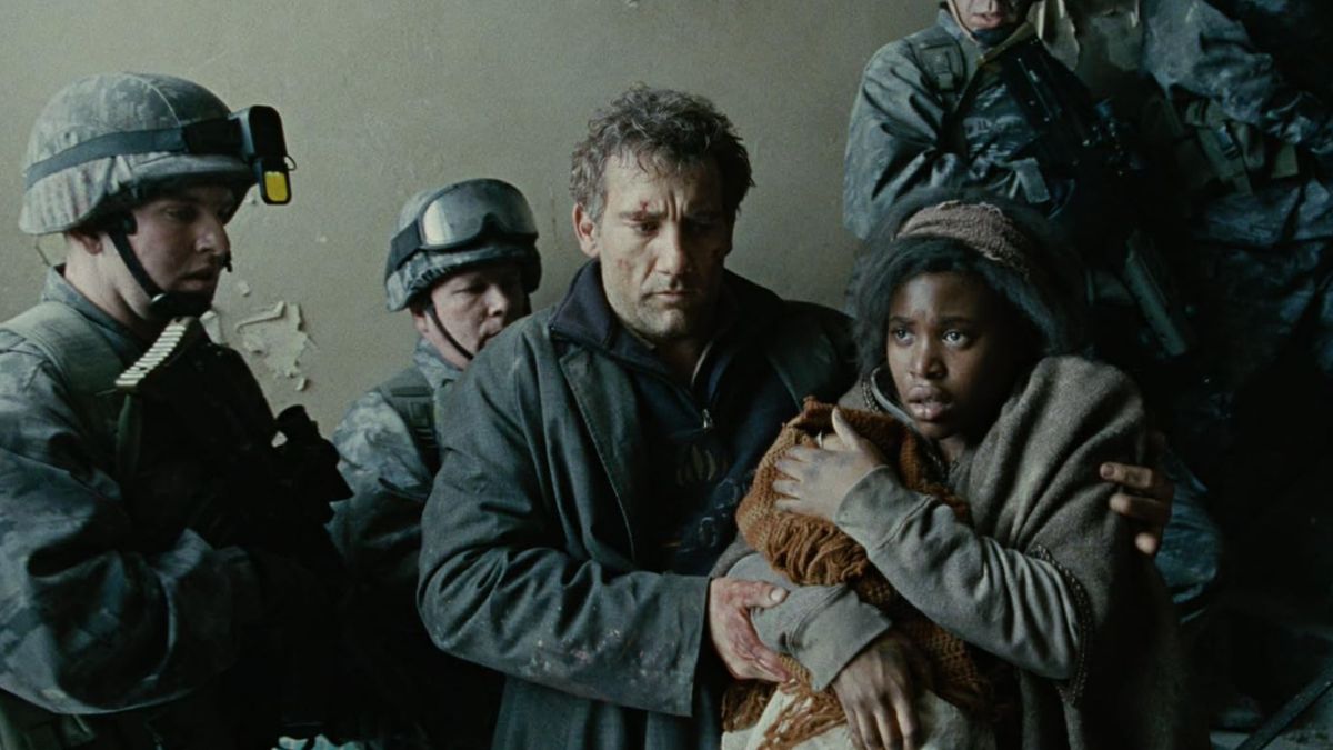 Una mujer que protege a un bebé se acurruca junto a un hombre que viste ropas ásperas y desgastadas, rodeado de soldados.