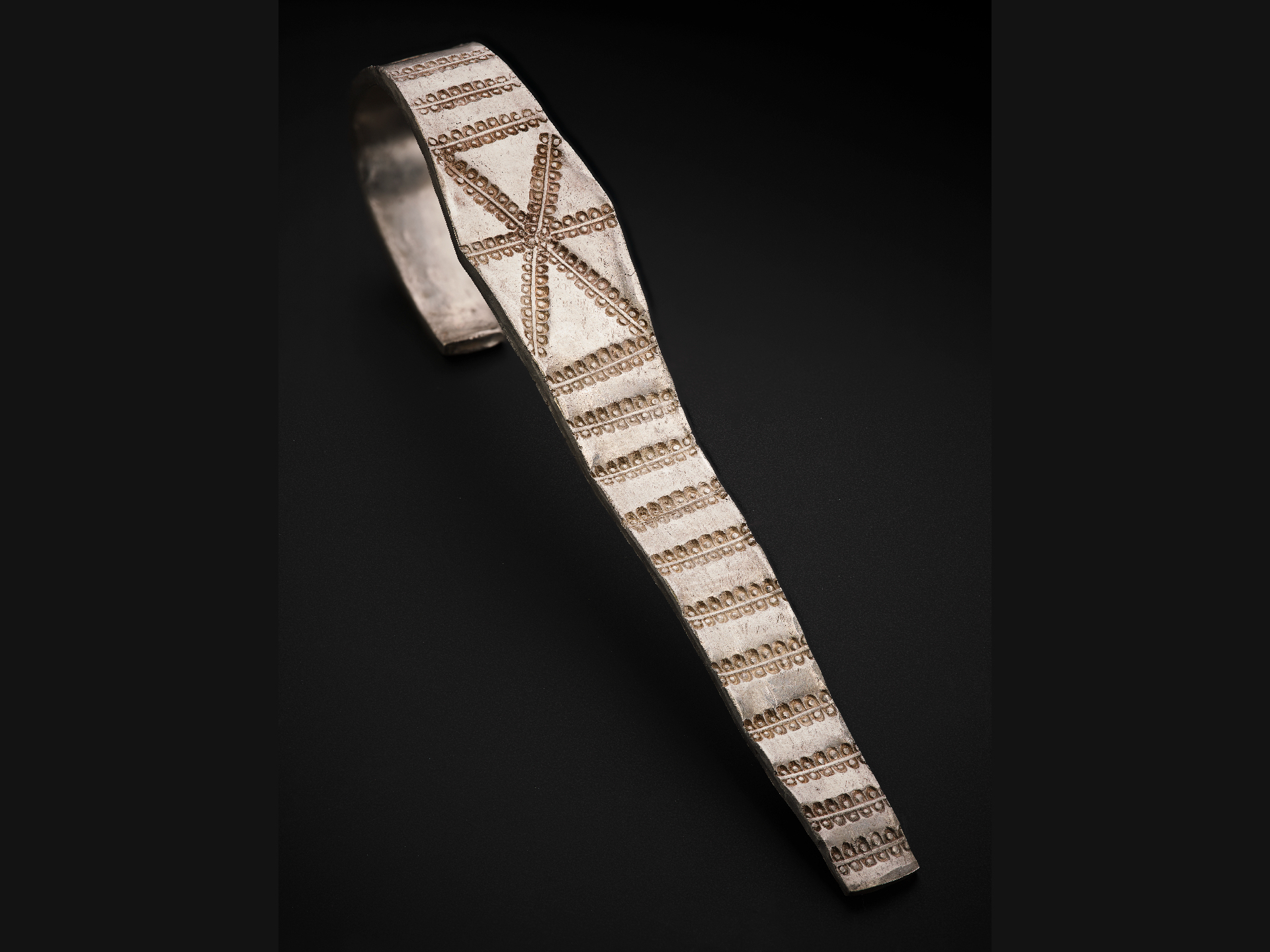 a silver armband with geometric designs