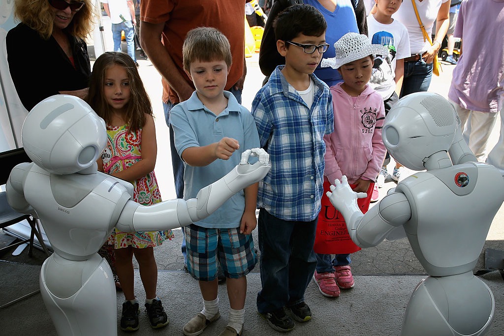 Children interact with Aldebaran�s Pepper robot during the Defense Advanced Research Projects Agency (DARPA) Robotics Challenge Expo at the Fairplex June 6, 2015 in Pomona, California.