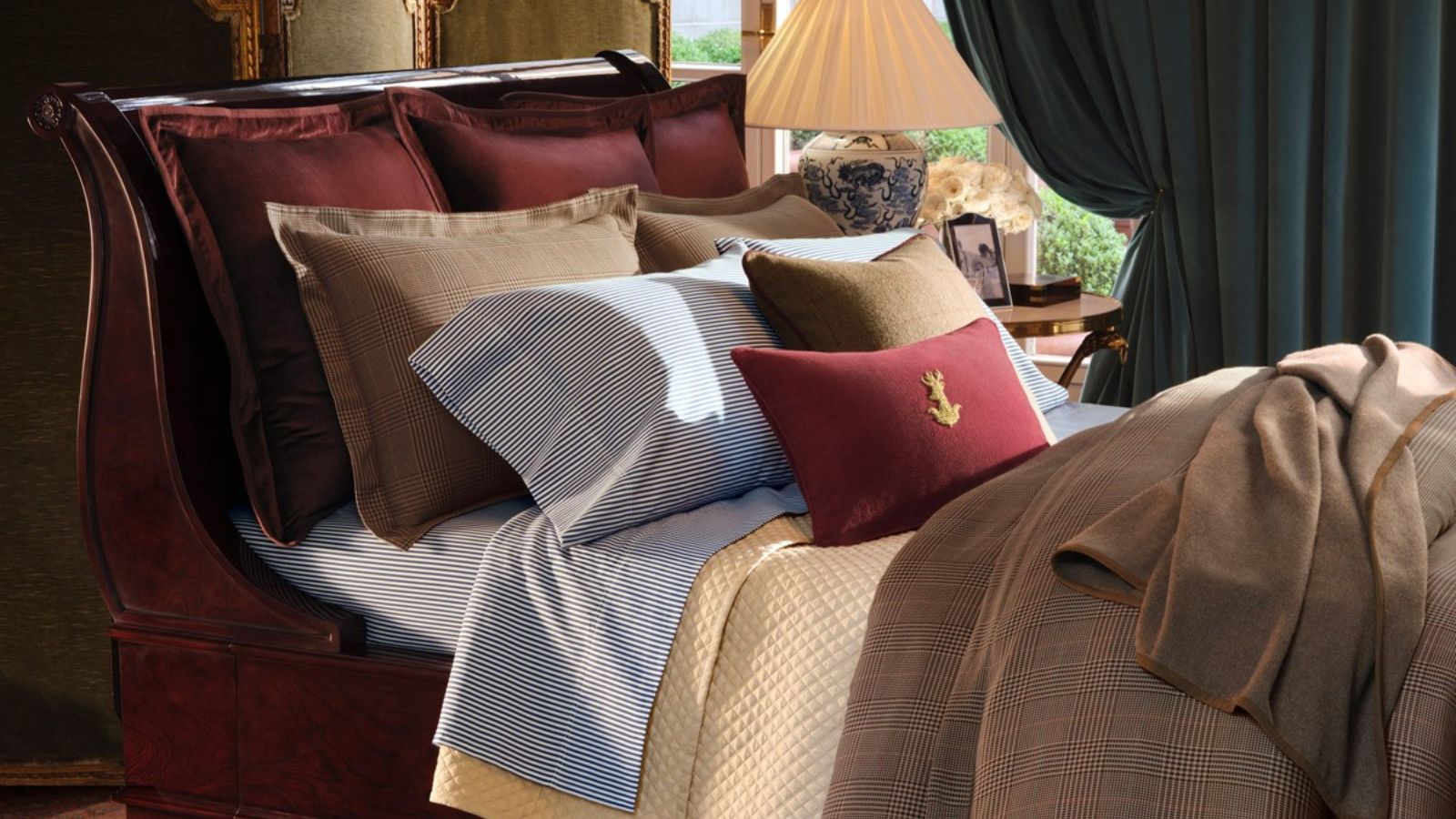 Ralph Lauren Palazzo bedding on a red sleigh bed frame against blue curtains.