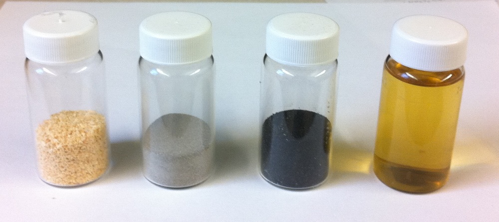Vials containing sawdust, catalyst, charred catalyst and gasoline made from sawdust.