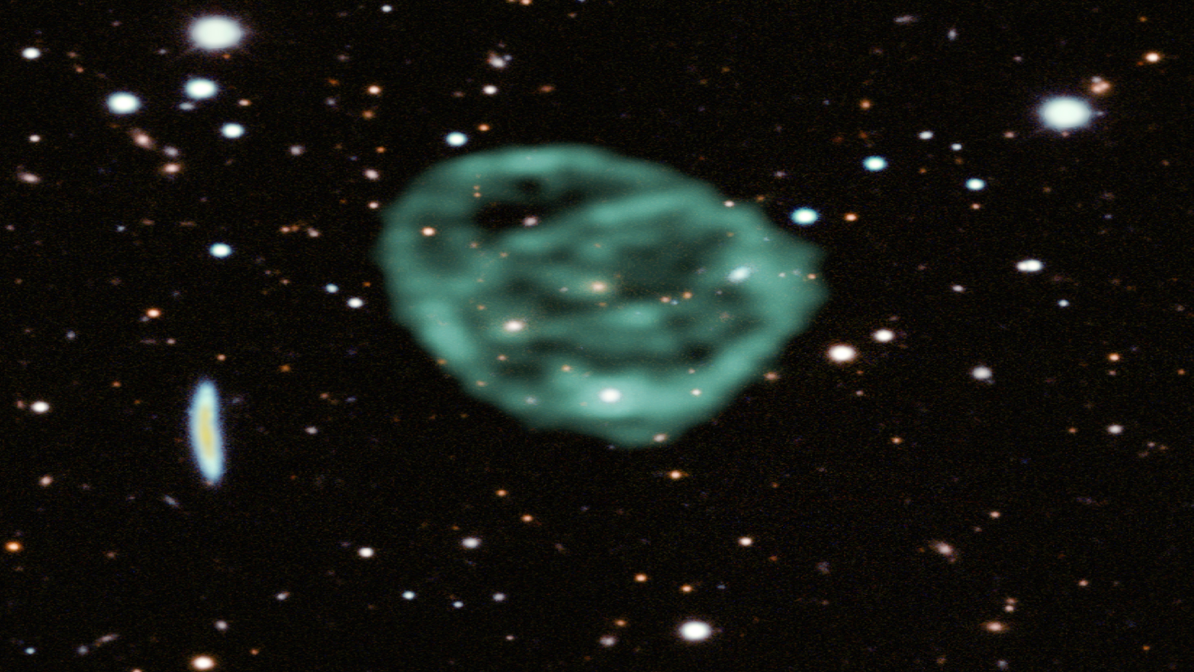 Data from SARAO&rsquo;s MeerKAT radio telescope data (green) showing the odd radio circles, is overlaid on optical and near infra-red data from the Dark Energy Survey.
