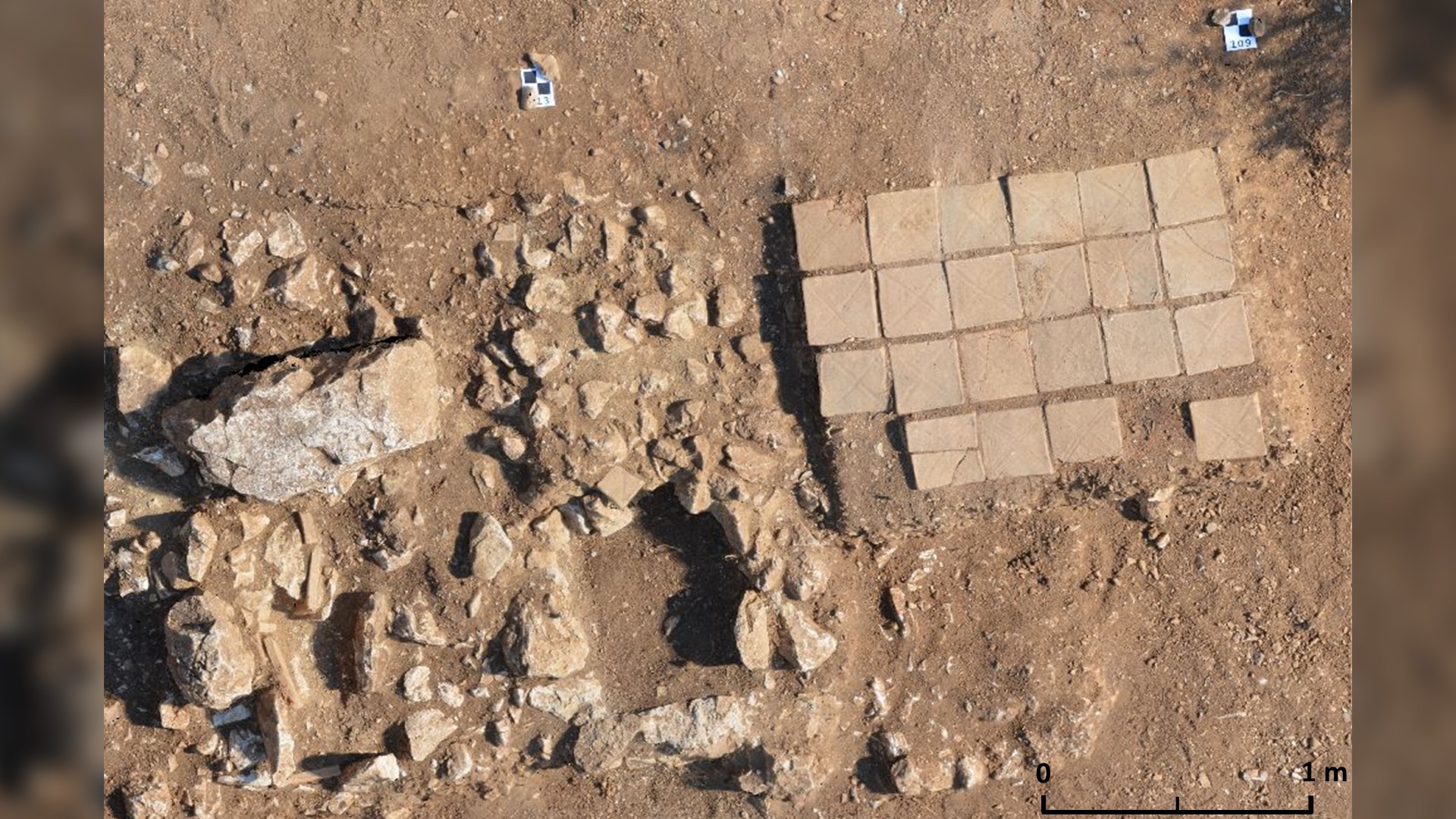 A photo of the cremation grave with bricks in place (right) next to two later tombs (left).