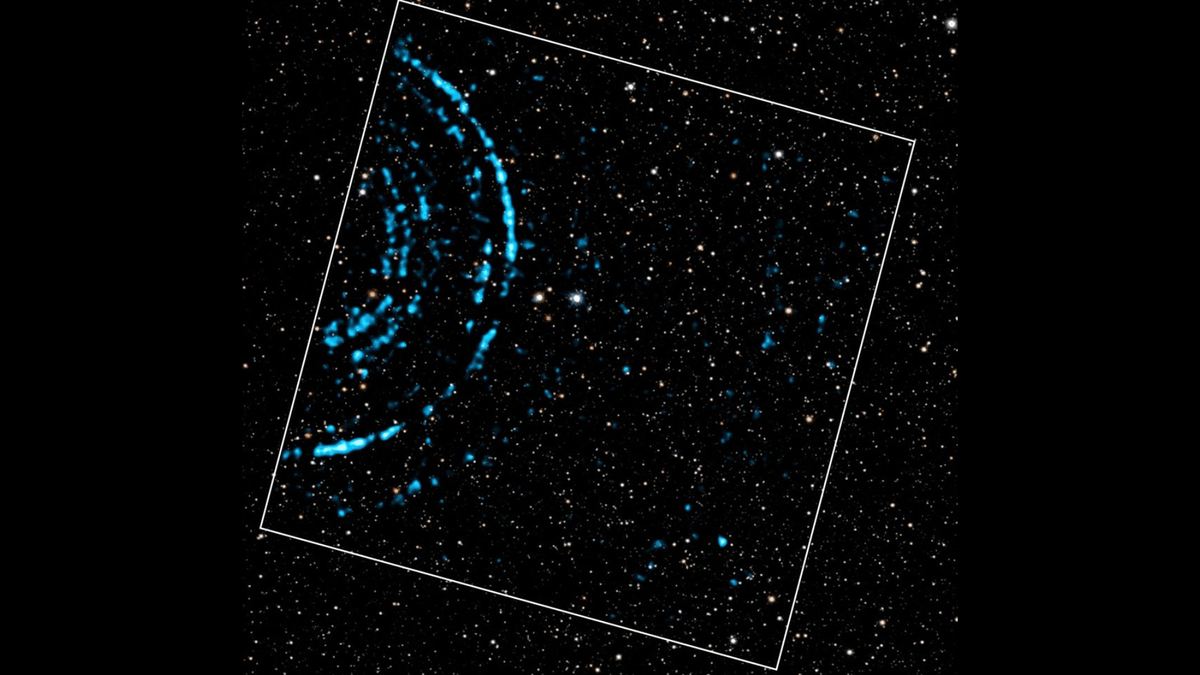 Sobre un fondo de estrellas hay luces azules brillantes que crean una serie de anillos moteados que hacen eco hacia afuera.