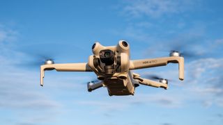 DJI Mini 4 Pro en vuelo con un cielo azul detrás