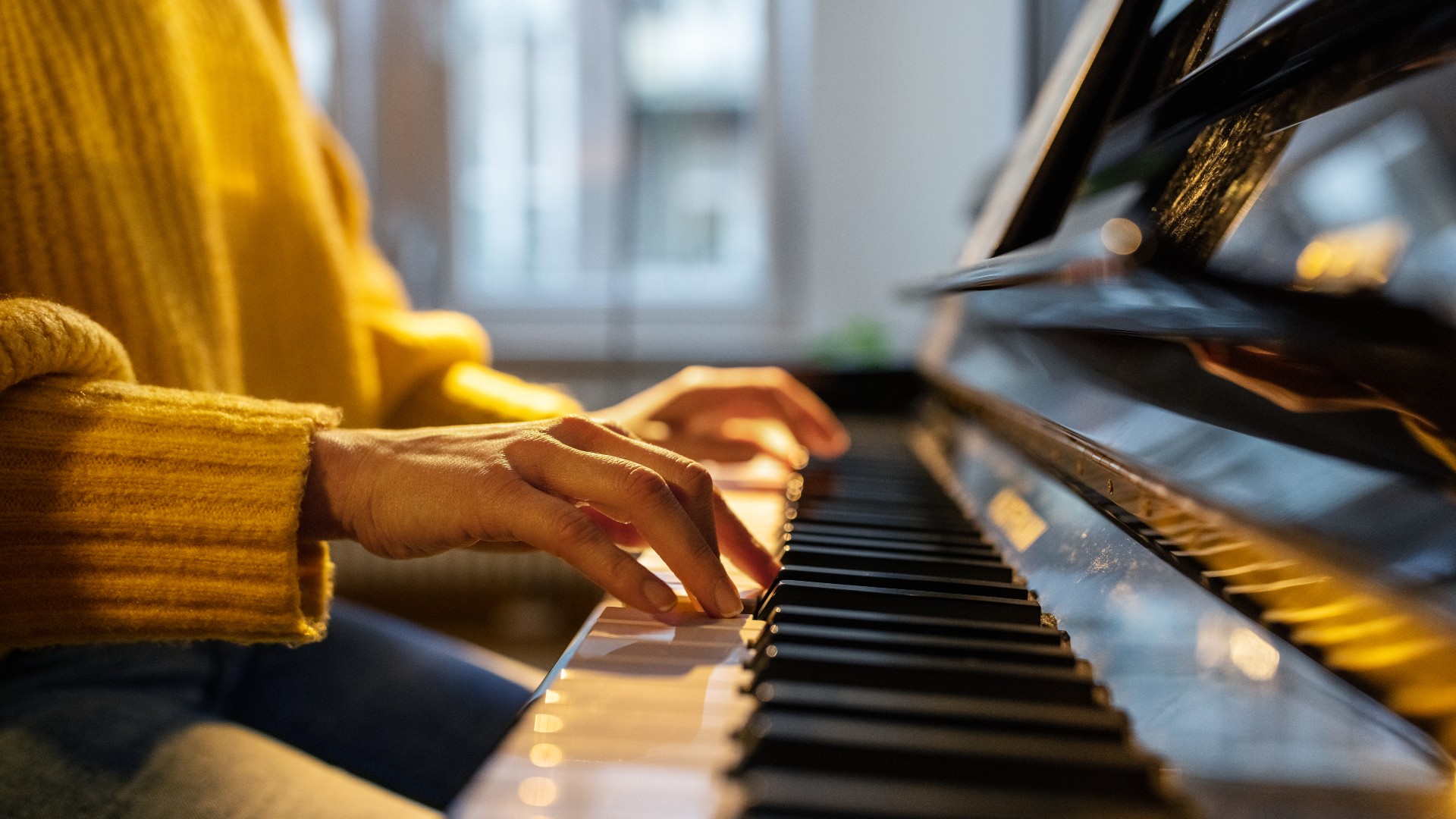 Close-up of a woman&rsquo;s hands as she plays the piano