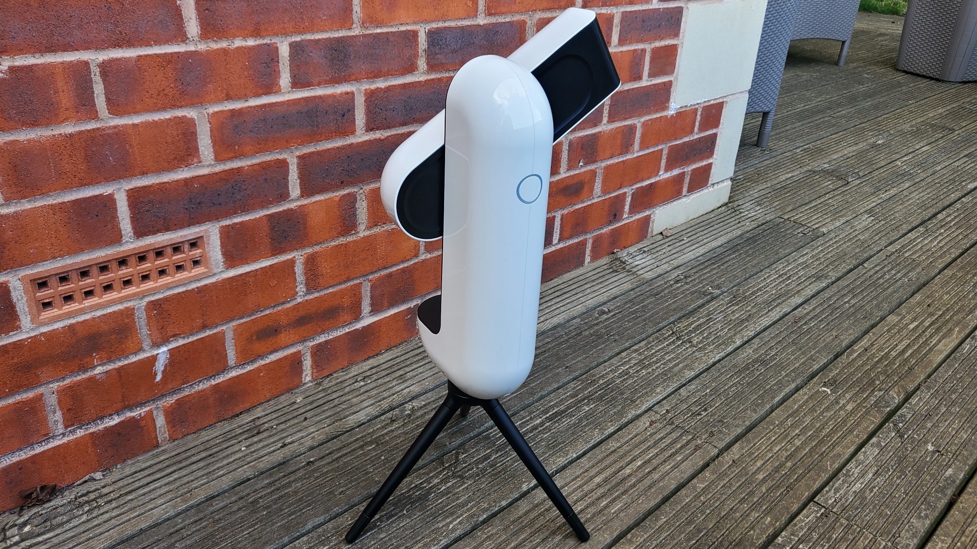 Side view of the Vaonis Vespera stood on a decked floor against a brick background.