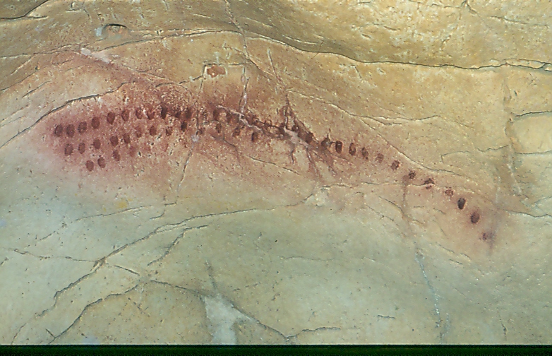 A swath of red fingerprints on a cave wall