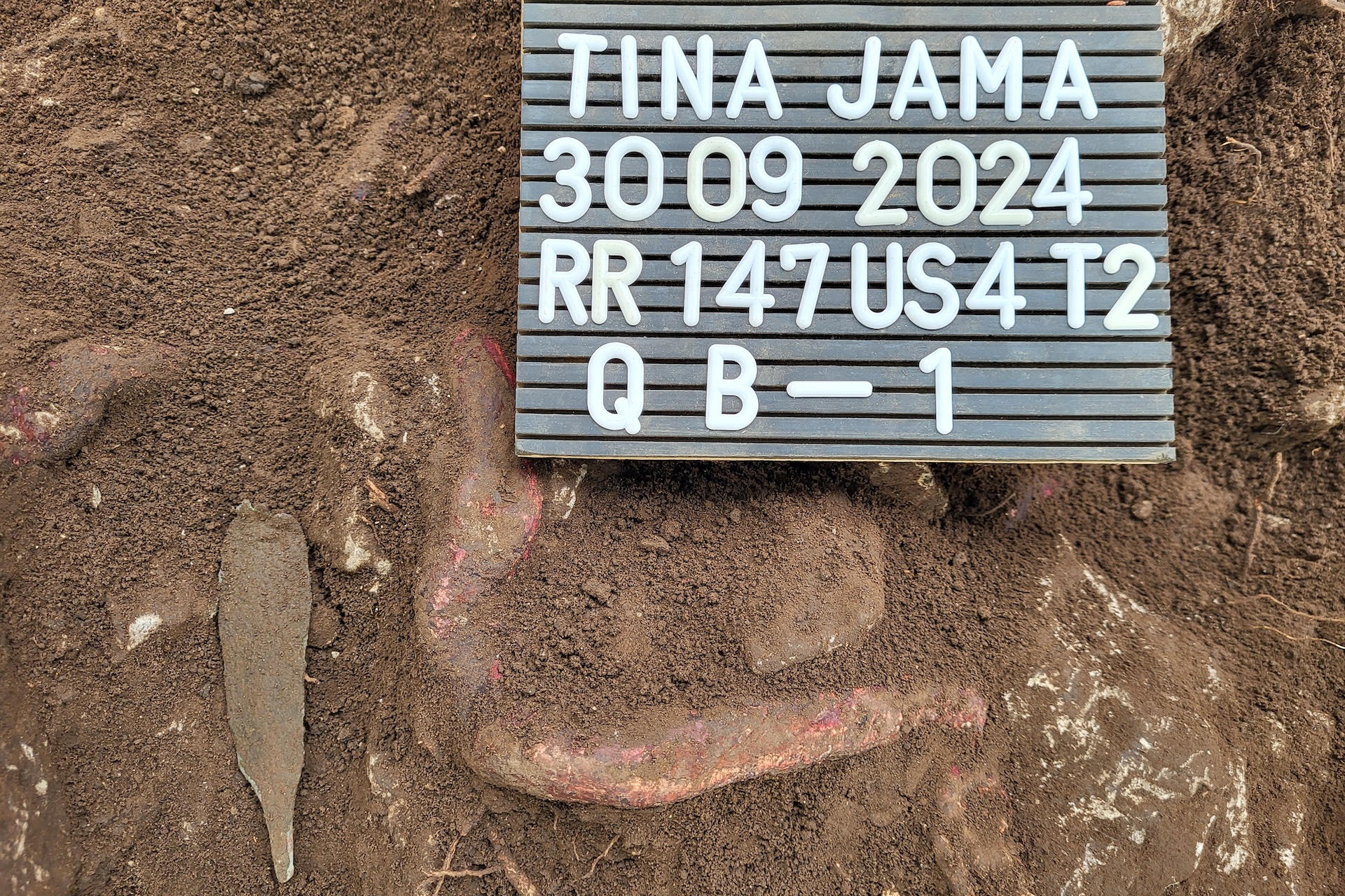 A dagger in the dirt with a sign next to it