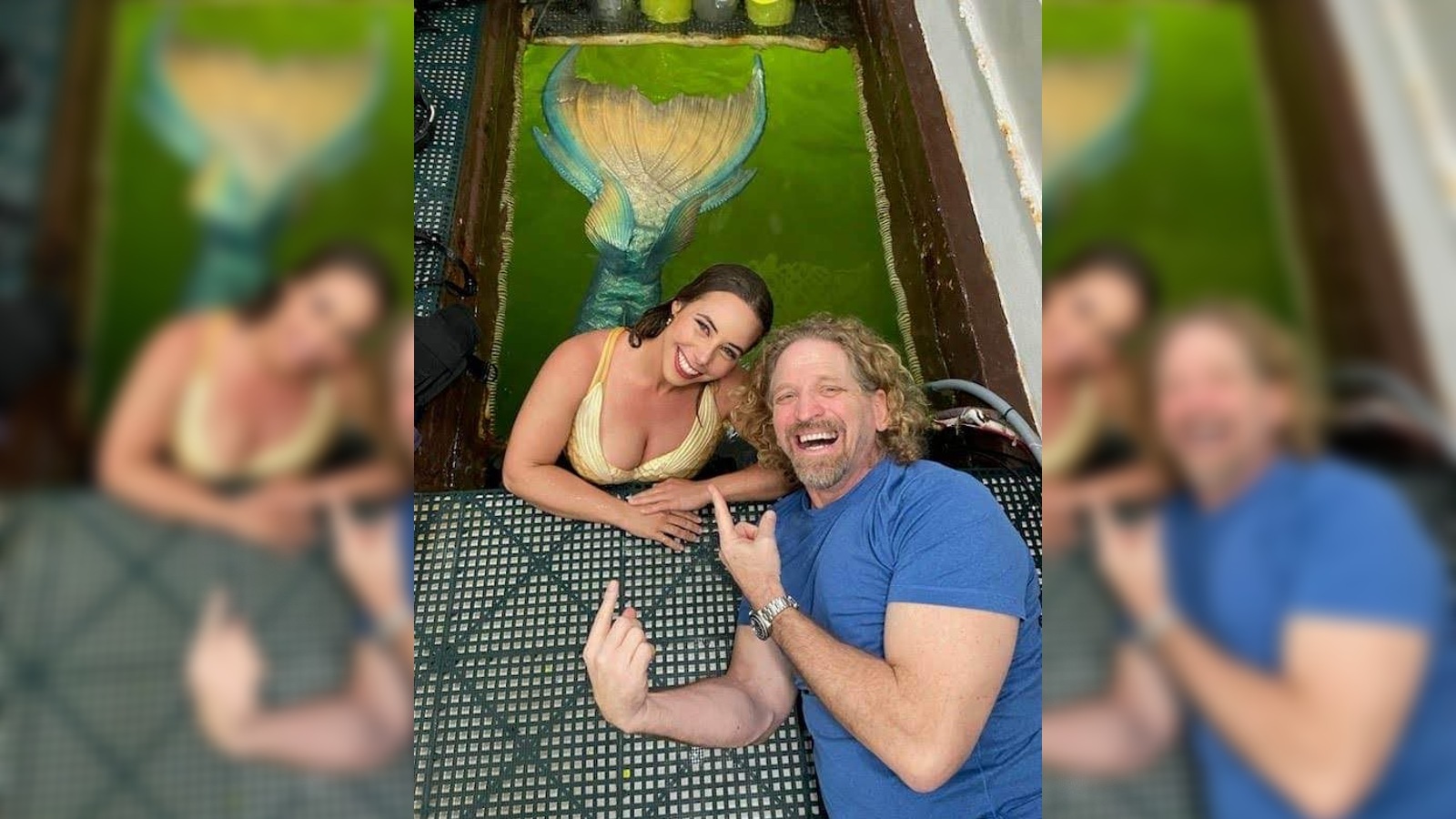 Jospeh Dituri lies next to a lady dressed as a mermaid in the habitat&rsquo;s moon pool