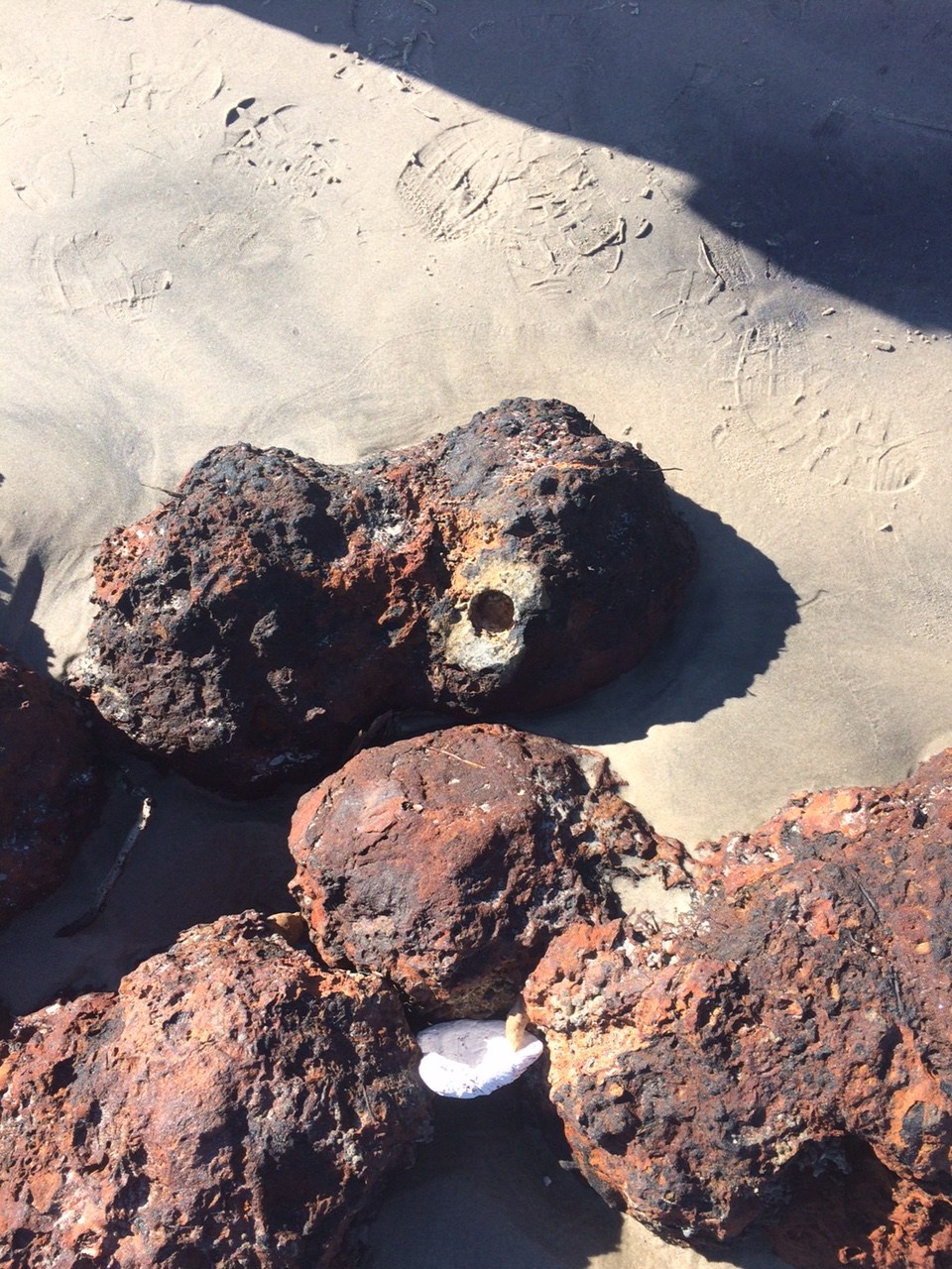 A pile of the discovered cannonballs. One has a cylindrical borehole where the timed fuse would have been placed.