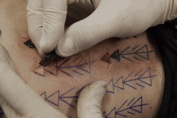 This shows Riday tattooing his own leg using a flake of obsidian to make it cut or incision before rubbing pigment into it. This is how some earlier studies had suggested Otzi&rsquo;s tattoo were made, but the latest study indicates this does not seem to be the case.