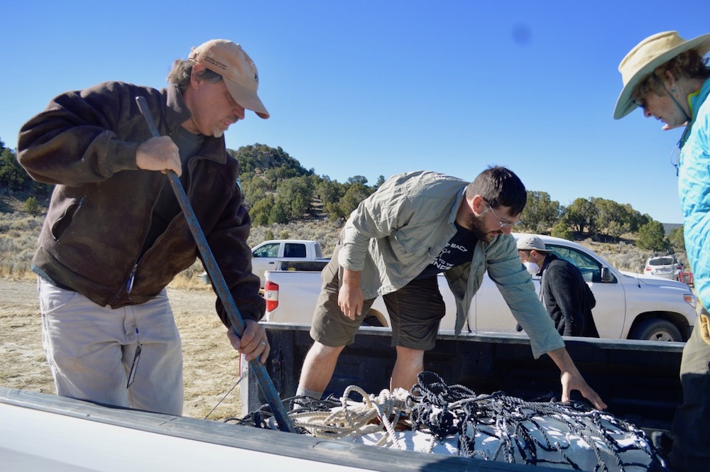 Tyler Birthisel (center), a preparation lab manager at the Natural History Museum of Utah, and Alan Titus (left), the monument paleontologist from the Bureau of Land Management (BLM), reposition a plaster-covered block containing one of the most complete tyrannosaur skeletons ever discovered. The 1,200-lb. (544 kilograms) piece was helicoptered to the truck as part of a cooperative research project between the Museum and the BLM.