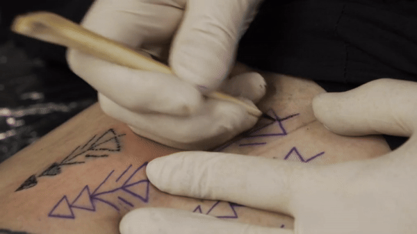 This shows co-author Danny Riday tattooing his own leg using an awl made from the bone of a white-tailed deer.