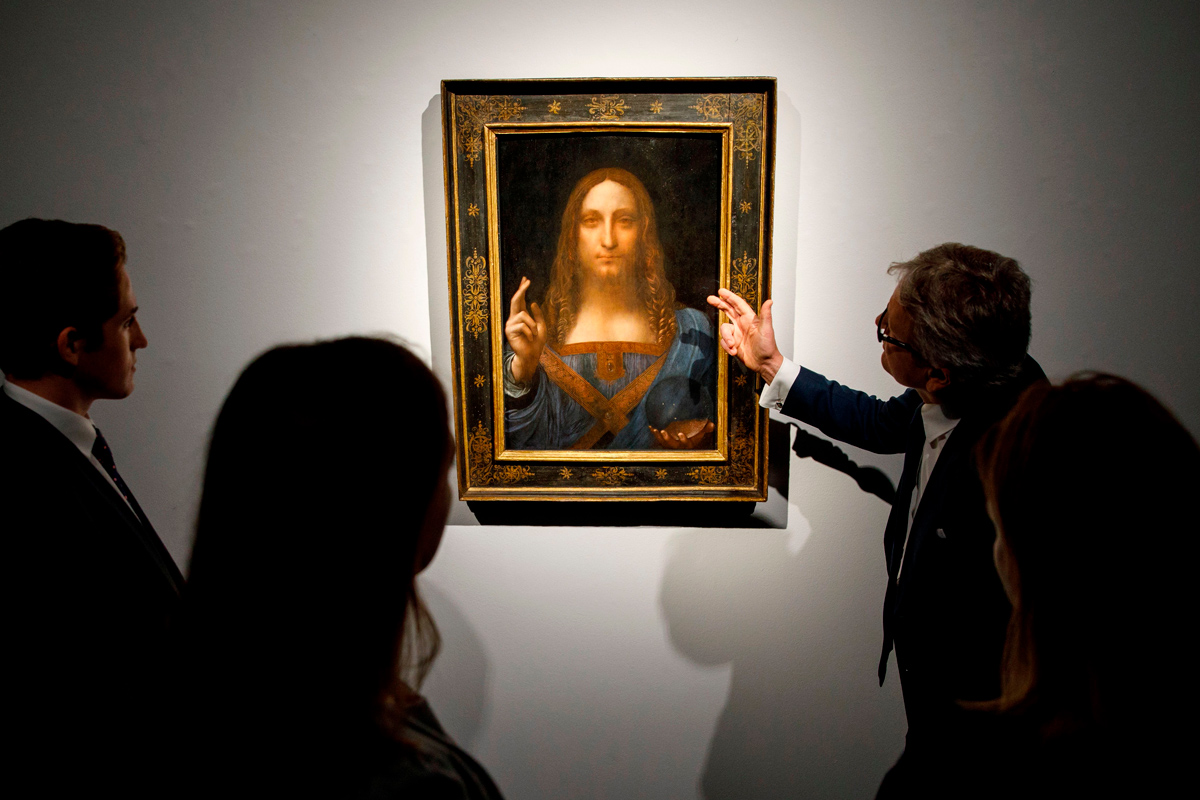 Christie&rsquo;s employees pose in front of a painting entitled &ldquo;Salvator Mundi&rdquo; by Leonardo da Vinci at Christie&rsquo;s auction house in central London on October 22, 2017.