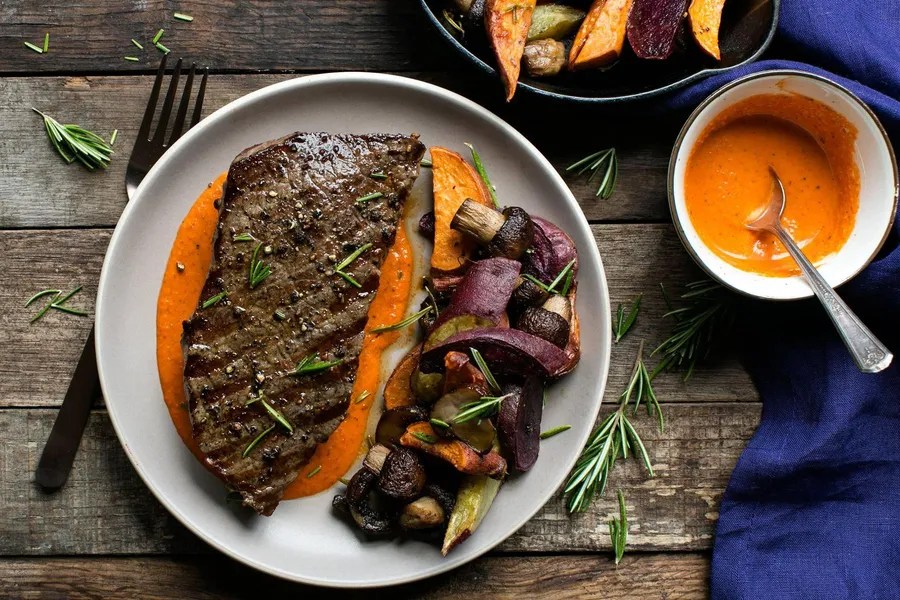 Steaks with red pepper sauce and rosemaryroasted vegetables