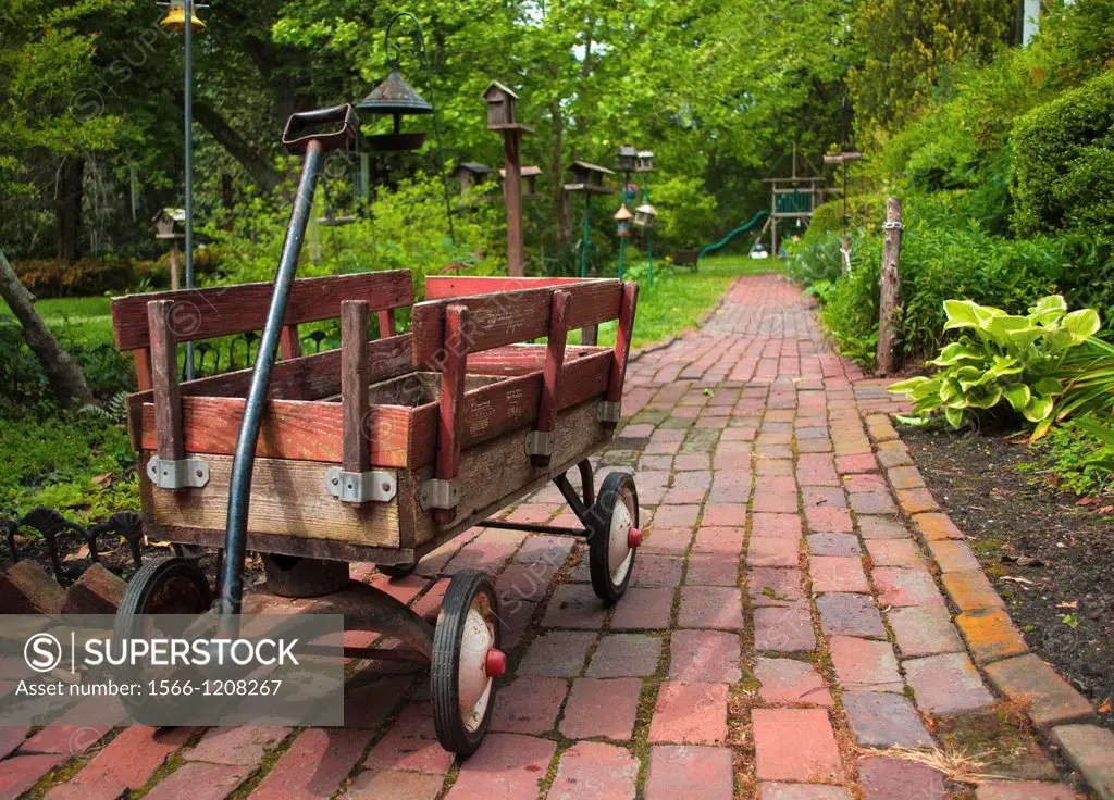 A child´s red wooden wagon on a path at Walter Place Gardens in Holly