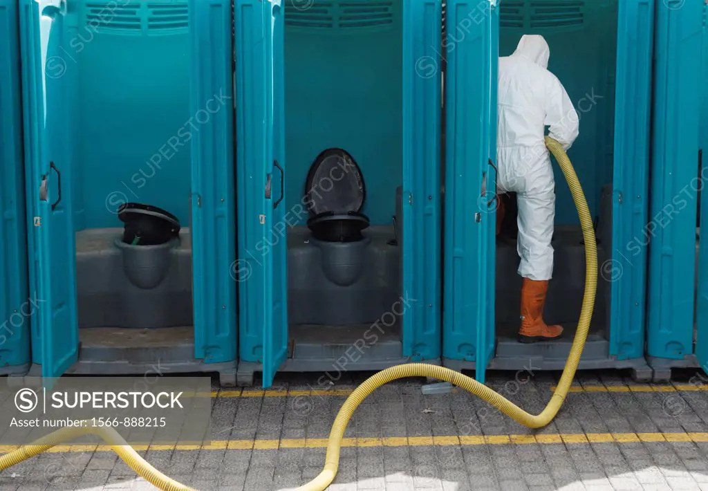 Man emptying and cleaning Portaloo chemical toilets at Las Palmas