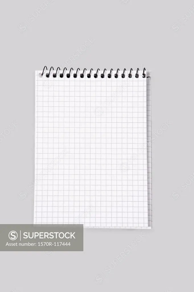 A spiral notebook with grid paper SuperStock