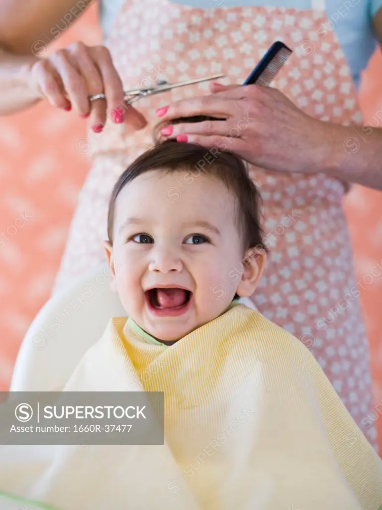 Baby getting a haircut. SuperStock