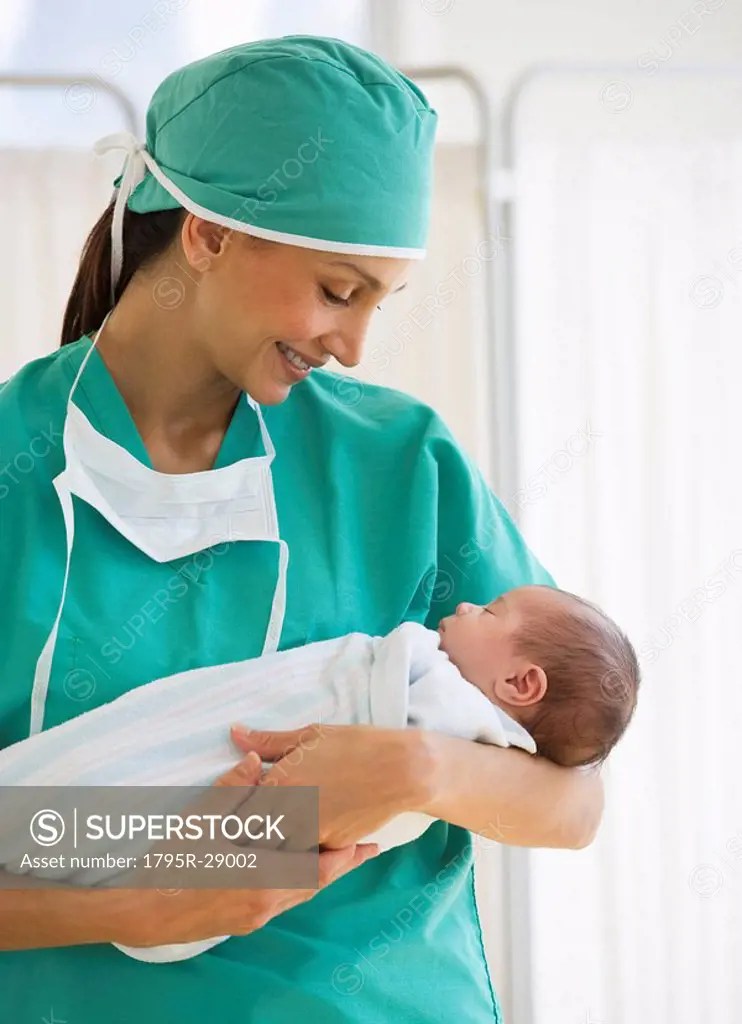 Nurse holding swaddled baby SuperStock