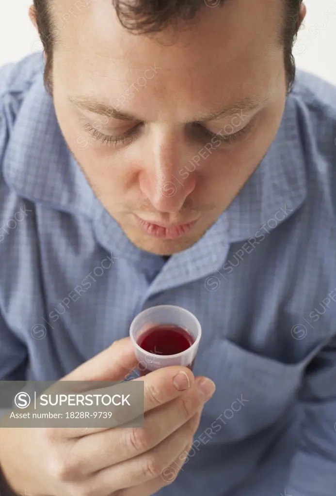 Man Drinking Cough Syrup SuperStock